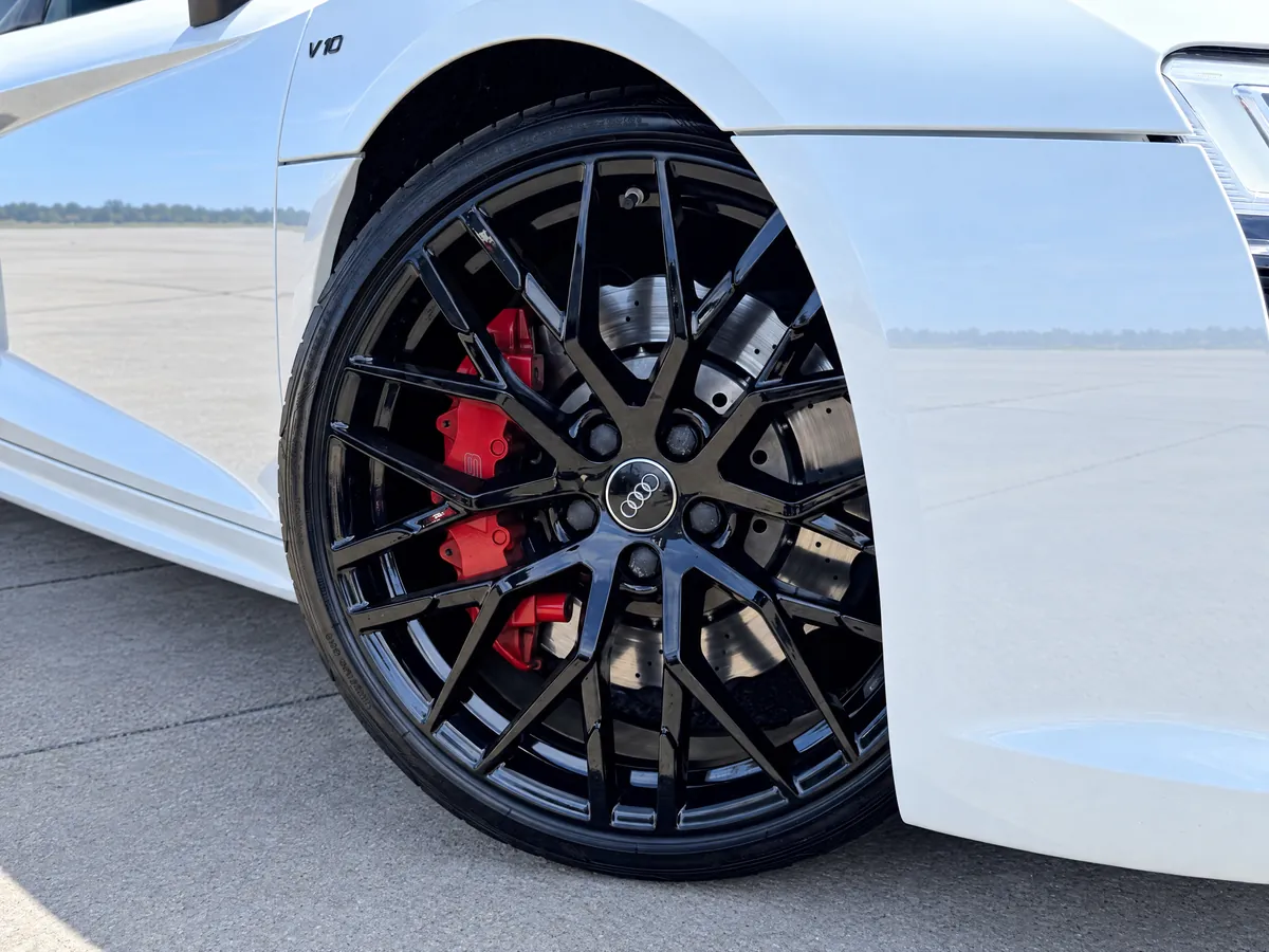 Gloss-black alloy wheel with red brake caliper on the Audi R8 Spyder
