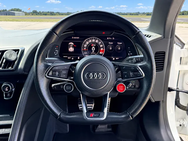 Flat-bottomed steering wheel with the red engine start button and virtual cockpit display